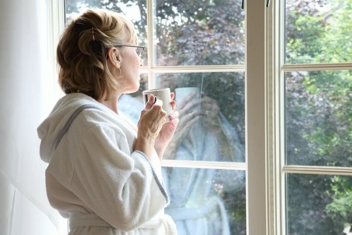 woman with menopause looking out a window