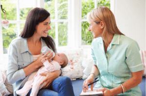 Mother With Baby Meeting With midwife At Home