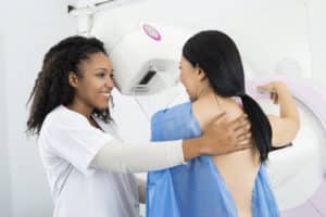 Happy Doctor Assisting Woman Undergoing Mammogram X ray Test