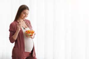 Smiling,Pregnant,Woman,Holding,Bowl,With,Fresh,Vegetable,Salad,,Eating